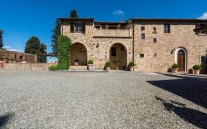een groot stenen gebouw met een grindoprit bij Villa le Mura in Montaione