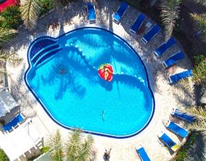 an overhead view of a large swimming pool with a beach umbrella at Hotel resort Rocca di Vadaro in Capo Vaticano