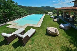 a pool with lounge chairs and a gazebo at Villa Le Croci Firenze in Bovecchio
