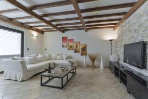 sala de estar con sofá blanco y TV en Villa Le Croci Firenze en Bovecchio