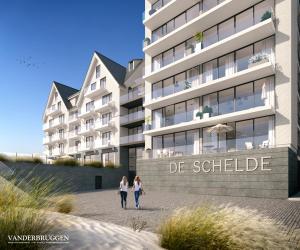 two people walking in front of a building at Hotel de Schelde in Cadzand-Bad