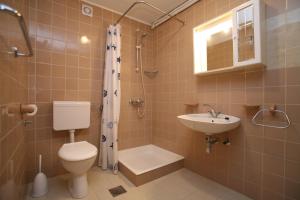 a bathroom with a toilet and a sink and a shower at Apartments Neda - Poreč South in Poreč +37 photos