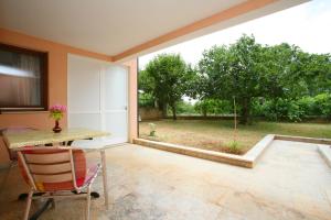 a patio with a table and a view of a yard at Apartments Neda - Poreč South in Poreč