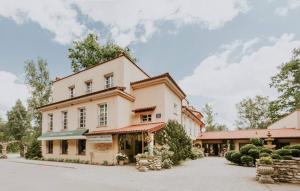 una grande casa bianca con un edificio di Villa Toscana Warszawa a Varsavia