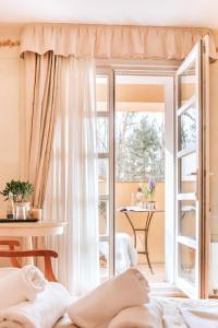 ワルシャワにあるVilla Toscana Warszawaの窓とテーブルが備わる客室です。