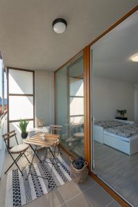 Zimmer mit einem Tisch und Stühlen sowie einem Balkon in der Unterkunft Apartmán Šantovka in Olomouc