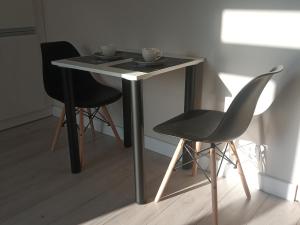 a table with two chairs and two cups on it at Kawalerka w Centrum Kalisza in Kalisz