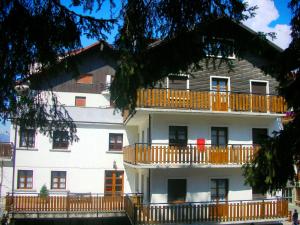 a large white building with balconies on it at Hotel Sport Cafe in Sauze dʼOulx