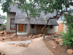 a small house with a thatched roof at Eclectic Safari Lodge in Mabula