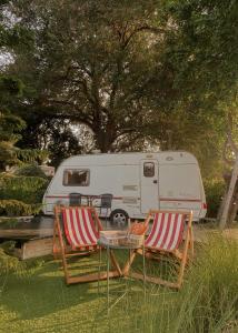 two chairs and a table in front of a trailer at Nice Nite Campervans in Phra Nakhon Si Ayutthaya