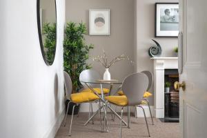 uma sala de jantar com uma mesa e cadeiras amarelas em St George's Place - Fab Cheltenham Town House em Cheltenham