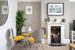 a dining room with a table and chairs and a fireplace at St George's Place - Fab Cheltenham Town House in Cheltenham