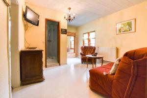 Una sala de estar con un sofá y un televisor. en Gite de la dime, en Ribeauvillé