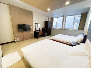 Habitación de hotel con 2 camas y TV de pantalla plana. en 花蓮花見你民宿 en Hualien