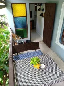 eine Bank mit einem Tisch mit einer Pflanze darauf in der Unterkunft Rose-Bud Cottage in Ko Chang