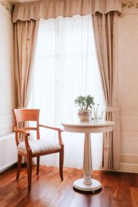 stół i krzesło przed oknem w obiekcie Villa Toscana Warszawa w Warszawie