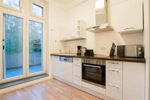 a kitchen with white appliances and a large window at RAJ Living - 1 or 3 Room Apartments - 20 Min Messe DUS and Old Town DUS in Düsseldorf