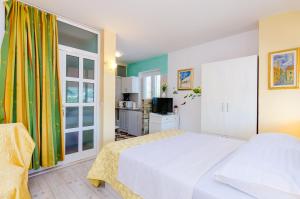a bedroom with a white bed and a window at Guest House Avdic in Dubrovnik