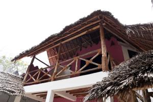 a house with a thatched roof on top of it at Sagando Bungalows Zanzibar in Michamvi