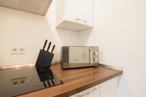una silla negra sentada en un mostrador junto a un microondas en Tolstov Apartments - 1 or 3 Room Apartments - 20 Min Messe DUS and Old Town DUS, en Düsseldorf 46 fotos más