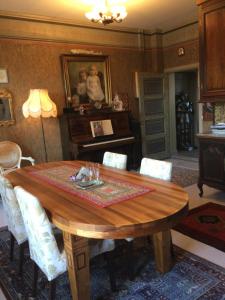 a dining room with a wooden table and a piano at Remuganes suite - Porvoon Linna in Porvoo