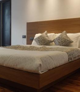 a bedroom with a large bed with a wooden headboard at Hotel Namgyal House in Gangtok