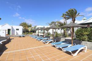 - fila di sedie a sdraio e ombrelloni presso il resort di Playa Park a Puerto del Carmen
