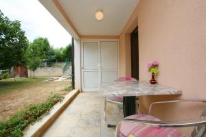 a table with a vase of flowers on a patio at Apartments Neda - Poreč South in Poreč