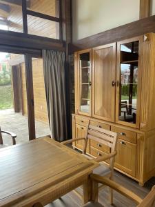 Villa Naya, Pirin Golf & Spa في بانسكو: غرفة طعام مع طاولة وخزانة خشبية