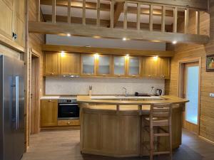a kitchen with wooden cabinets and a sink and a stove at Villa Naya, Pirin Golf & Spa in Bansko