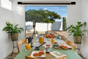 因赫尼奧的住宿－Los Cipreses，阳台上的桌子上摆放着食物和橙汁