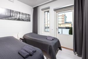 um quarto com 2 camas e uma janela em Valoisa parvekkeellinen kaksio, oma parkkipaikka em Tampere