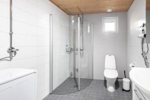 a white bathroom with a shower and a toilet at Valoisa parvekkeellinen kaksio, oma parkkipaikka in Tampere