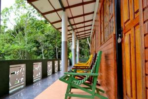 a row of green chairs sitting on a porch at Green Valley Holiday Resort in Haputale