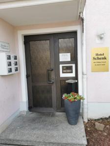 uma porta com um vaso de flores na frente dela em Hotel Schenk em Pirmasens