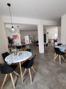 uma sala de estar com duas mesas e cadeiras e um quarto em Hotel Schenk em Pirmasens