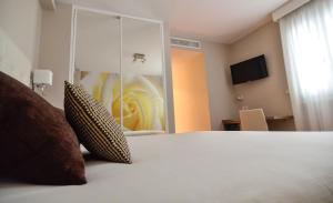 Hotel Jucamar في كانجاس دي مورازو: غرفة نوم بسرير كبير وبجدار زجاجي