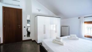 - une chambre avec 2 lits blancs et une armoire dans l'établissement Viale Hambury 51, à Alassio