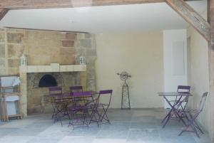 um quarto com cadeiras roxas e uma lareira de pedra em Le Pavillon de la Lanterne em Rochecorbon