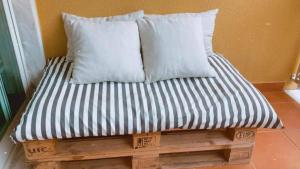 1 cama con 2 almohadas sobre una plataforma de madera en Santa Lovers en Santa Cruz