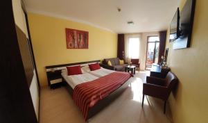 sypialnia z łóżkiem z czerwonymi poduszkami i kanapą w obiekcie Apartmán AQUAPARK - Hotel Bešeňová w Beszeniowej