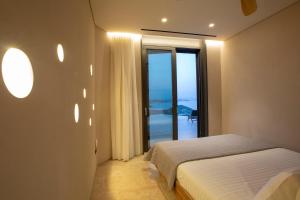 um quarto com uma cama e vista para o oceano em Blooms of Sivota Bay - Luxury villas with private heated pool em Syvota