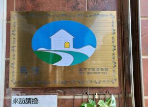 a sign on a wall with a house in the water at 1986 Travel Hall in Anping