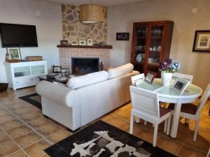 sala de estar con sofá y mesa en Casa Rural El Duende, en Monreal del Llano