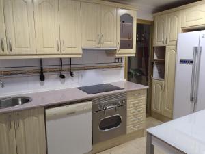 贝尼多姆Principado Marina的配有木质橱柜和白色冰箱的厨房