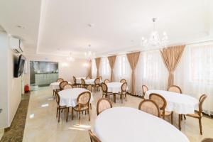 a dining room with white tables and chairs at Ilinka Hotel in Vladimir