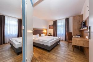 ein Hotelzimmer mit 2 Betten und einem Schreibtisch in der Unterkunft Ratskeller Lauda in Lauda-Königshofen
