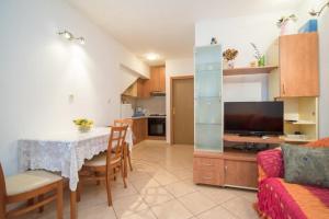 a kitchen and living room with a table and a couch at Apartments Longo in Supetar