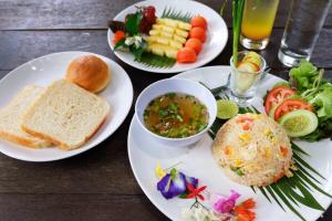 una mesa con tres platos de comida. en Kongkarn Resort and Farmstay, en Ban Pak Ngam