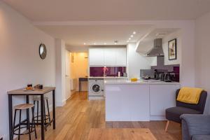 ニューベリーにあるCozy 2 Bedroom Apartment in Newbury Town Centre - SLEEPS 7 with NETFLIX and WiFiのキッチン、リビングルーム(カウンター、テーブル付)